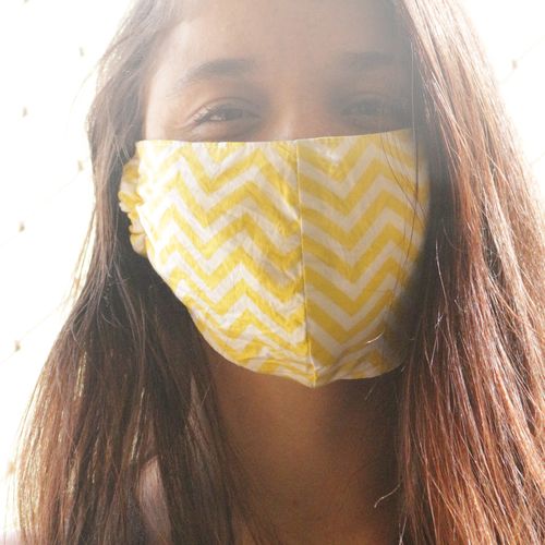 Mädchen mit Mundschutz-Maske vor dem Gesicht