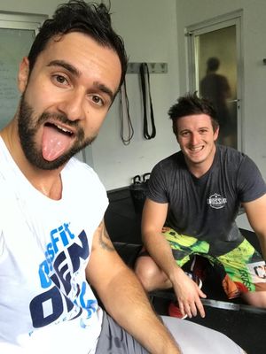zwei junge Männer beim Workout. Einer zeigt die Zunge einer lacht.